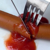 sausage with ketchup and cutlery; kethup looks like blood