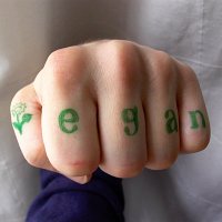 hand with the word 'vegan' written on the fingers